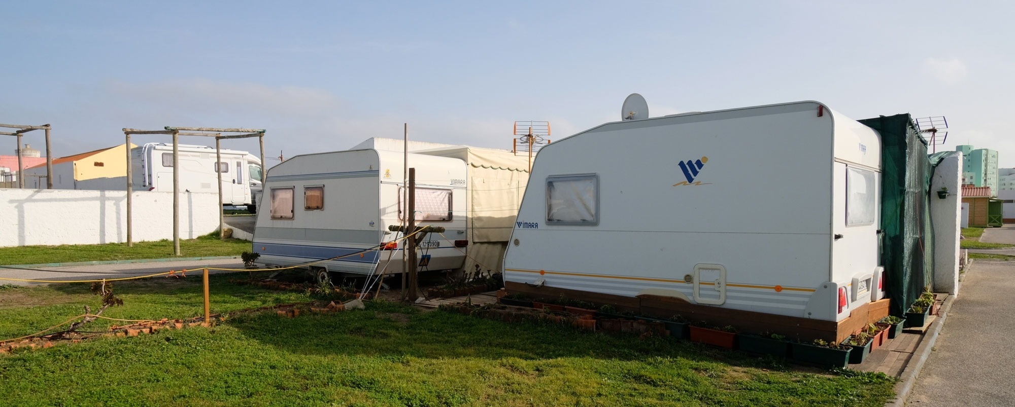 un hombre y una mujer se sientan frente a una furgoneta de camper