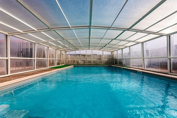 uma piscina coberta com um telhado de plástico transparente