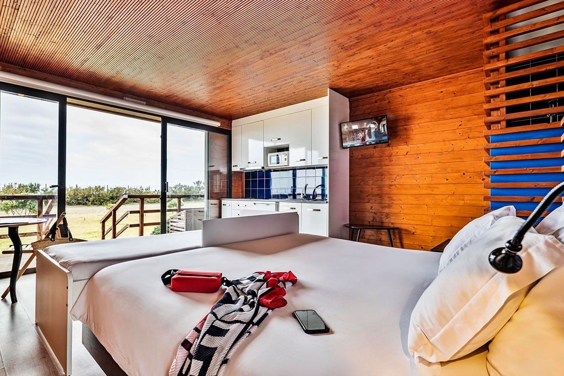 um quarto de hotel com uma cama e uma parede roxa