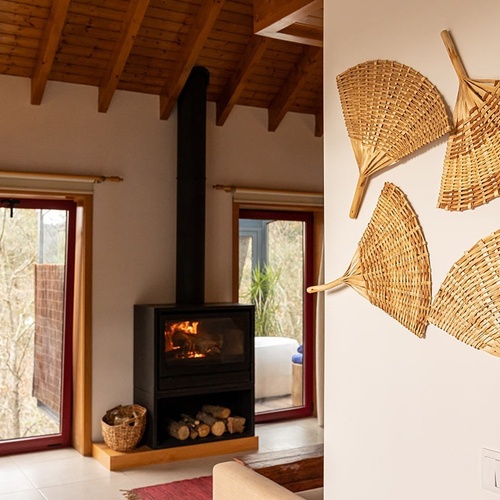 uma sala de estar com lareira e ventiladores pendurados na parede