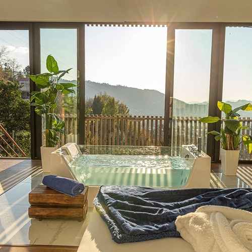 uma sala com uma banheira e uma janela com vista para as montanhas