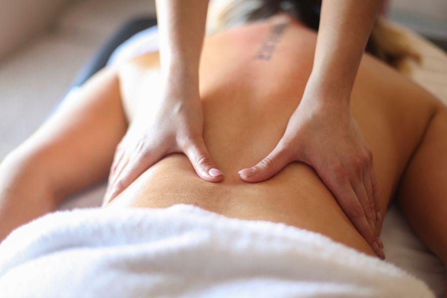 una mujer con un tatuaje en la espalda recibe un masaje