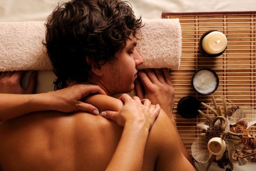 a man is getting a massage with a candle in the background