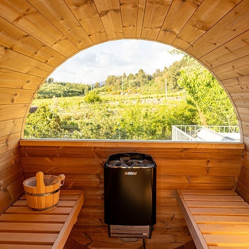 a sauna with a harvia heater and a wooden bucket