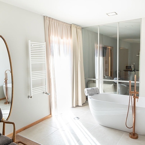 um banheiro com uma banheira e um espelho