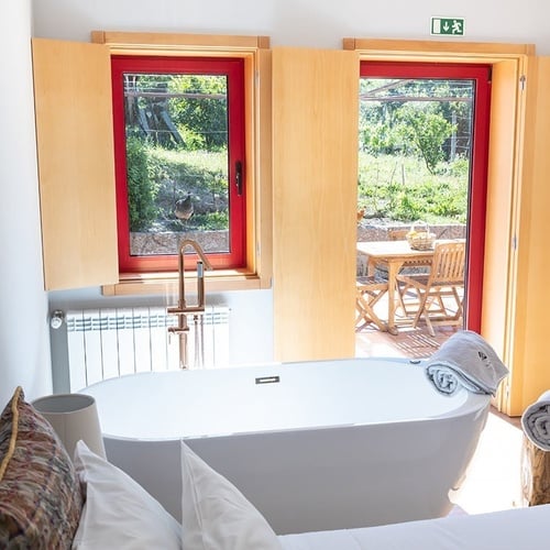 um quarto com uma banheira e uma janela vermelha