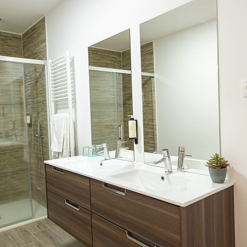 um banheiro com duas pias e um secador de cabelo