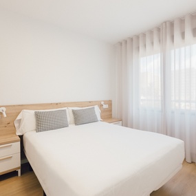 a bedroom with a white bed and white curtains