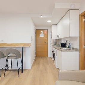 una cocina con una mesa de madera y taburetes