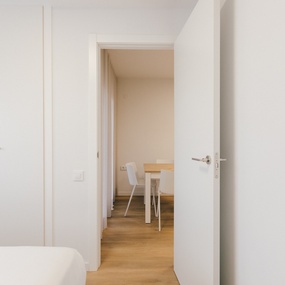 a white door open to a room with a table and chairs