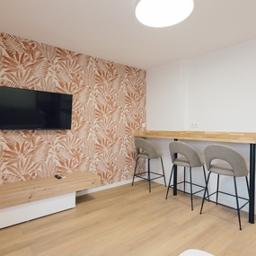 a flat screen tv is mounted on a wall above a wooden table