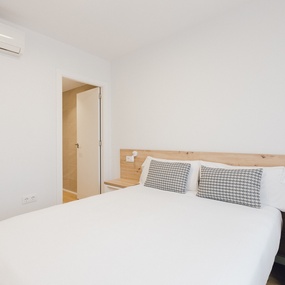 a bedroom with a white bed and a wooden headboard