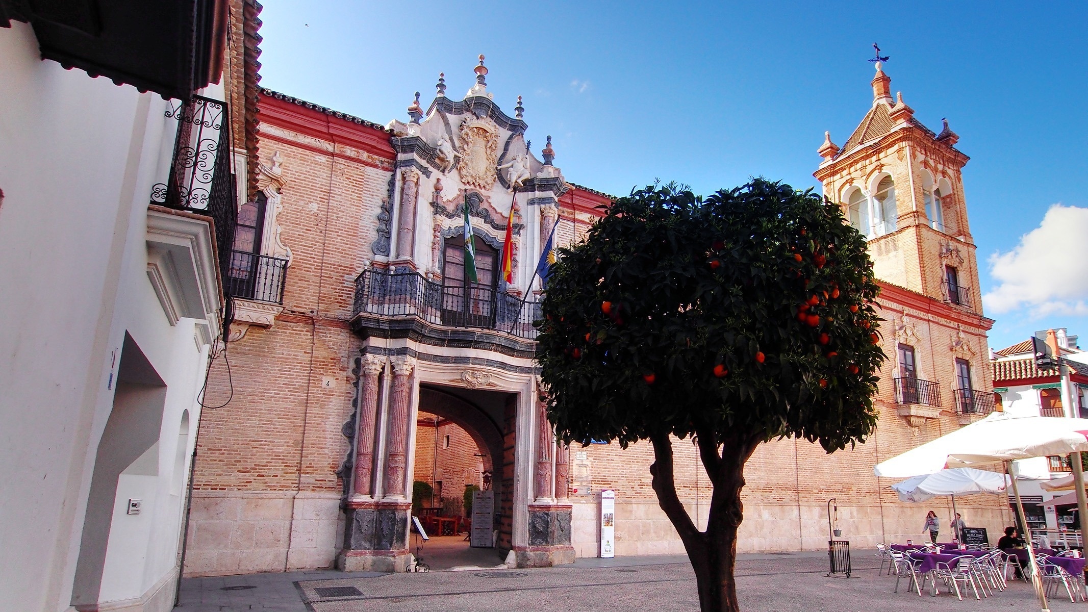 un edificio de ladrillo con un árbol naranja frente a él