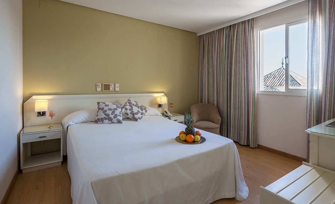 una habitación de hotel con una cama y una mesa de frutas