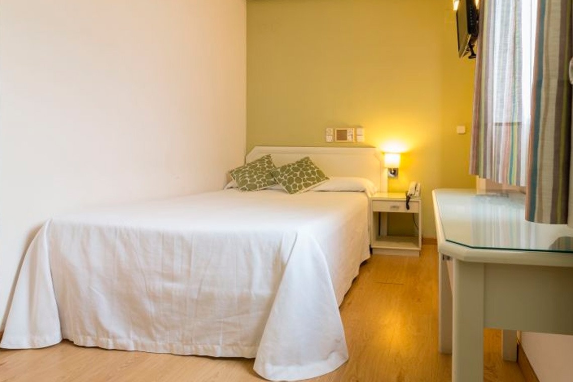un dormitorio con una cama y un espejo