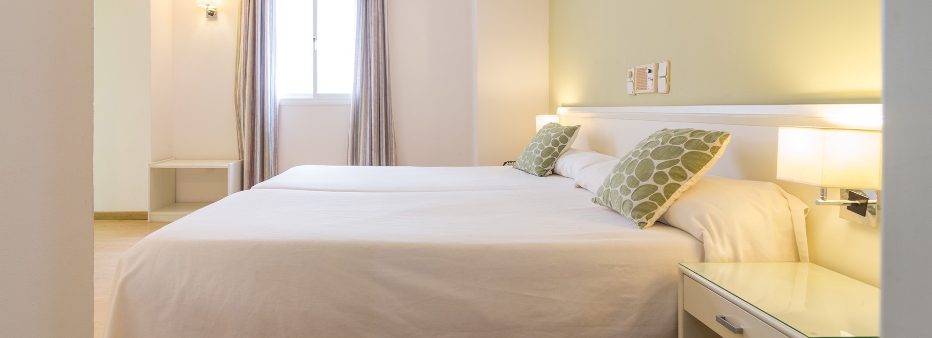 una habitación con dos camas y una mesita de noche