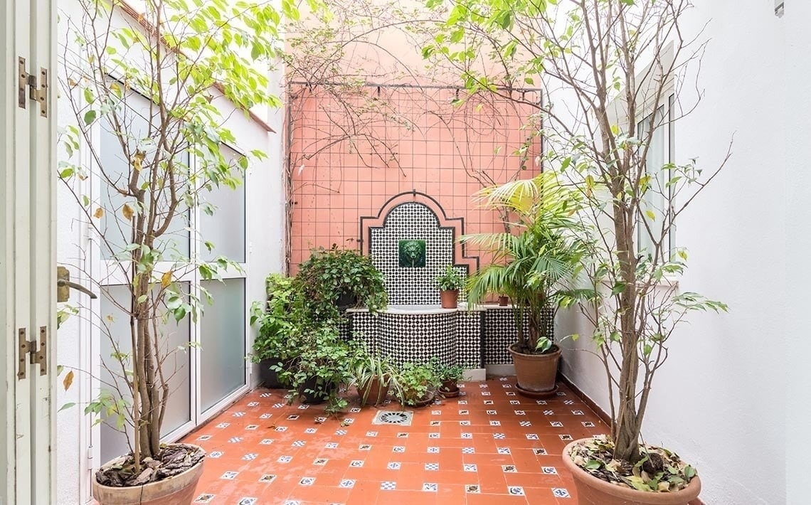 a small courtyard with potted plants and a fountain