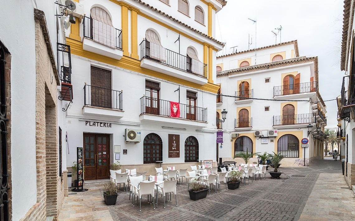 a group of people jumping in the air with a paraglider in the background