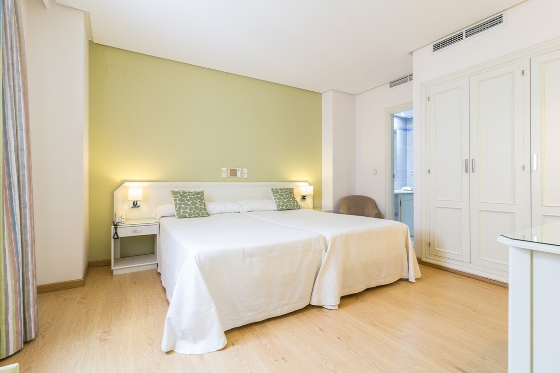 una habitación pequeña con una cama y un aire acondicionado