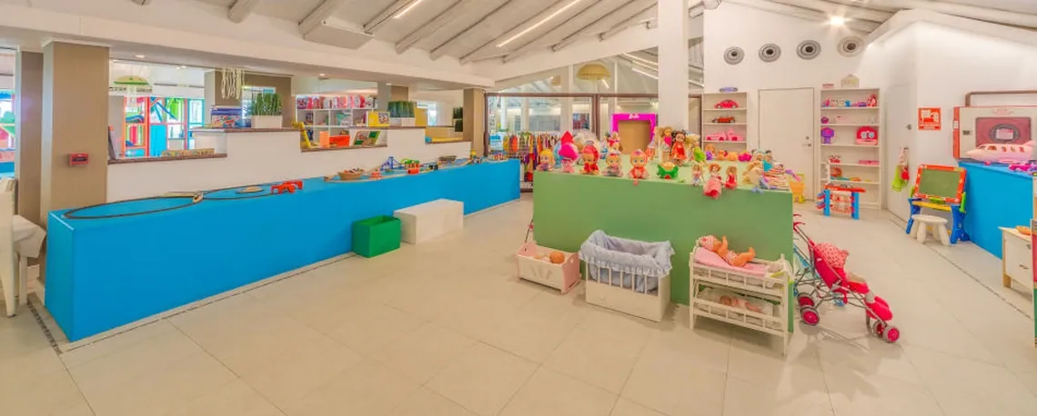 Sala de juegos para niños con juguetes y cunas para muñecas. El hotel ofrece Playa Esperanza Resort para familias.