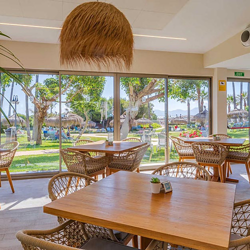 Comedor del hotel con vista a la playa y zona ajardinada. Ideal para tu Playa Esperanza Resort.