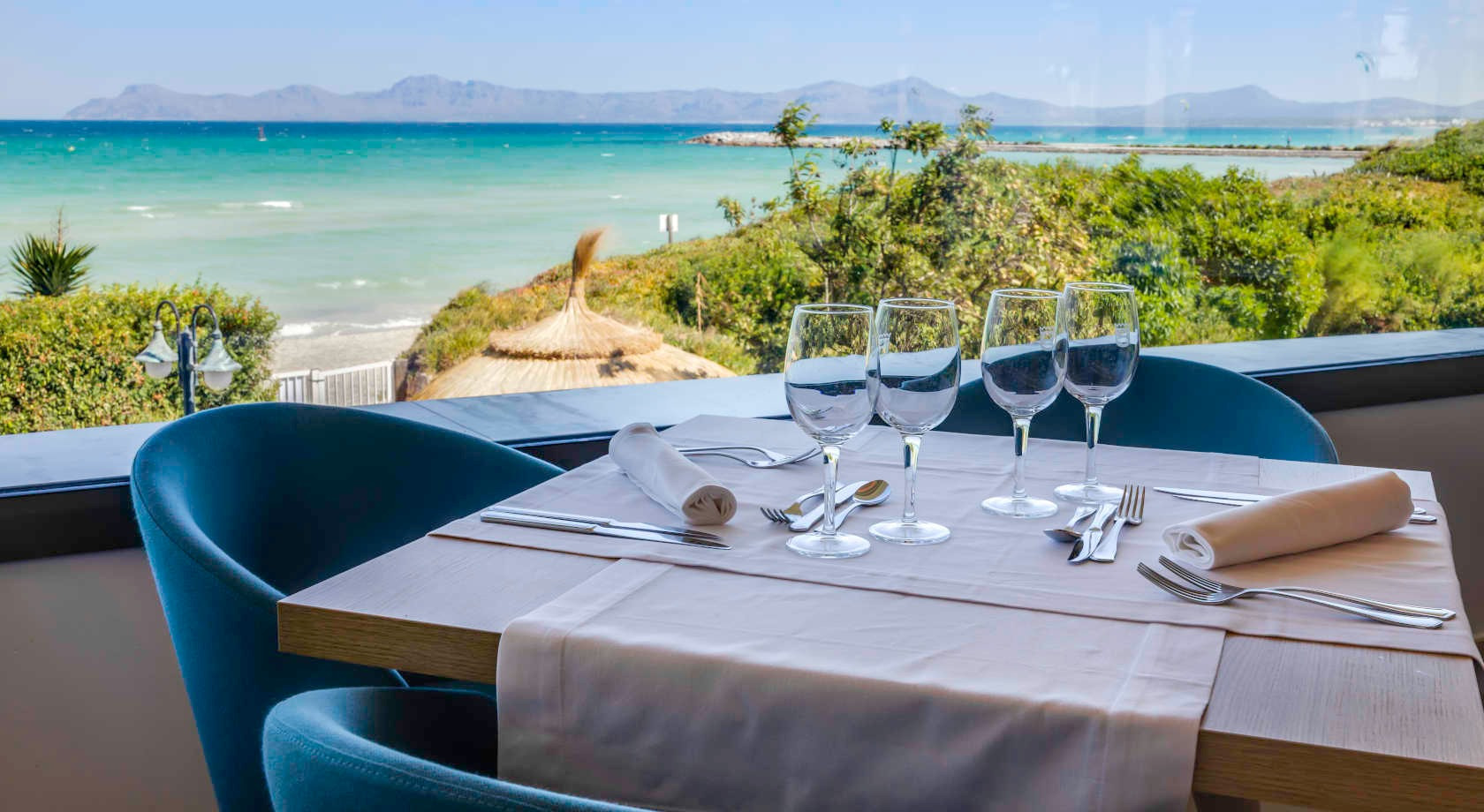 Mesa de restaurante con vista al marPlaya Esperanza Resort, ideal para cenas románticas.