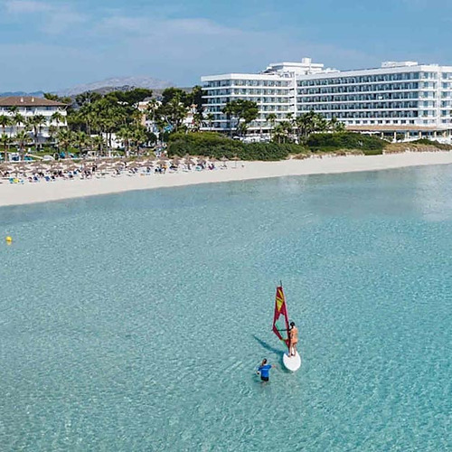 Vista de Playa Esperanza Resort en la playa con windsurf y aguas cristalinas.