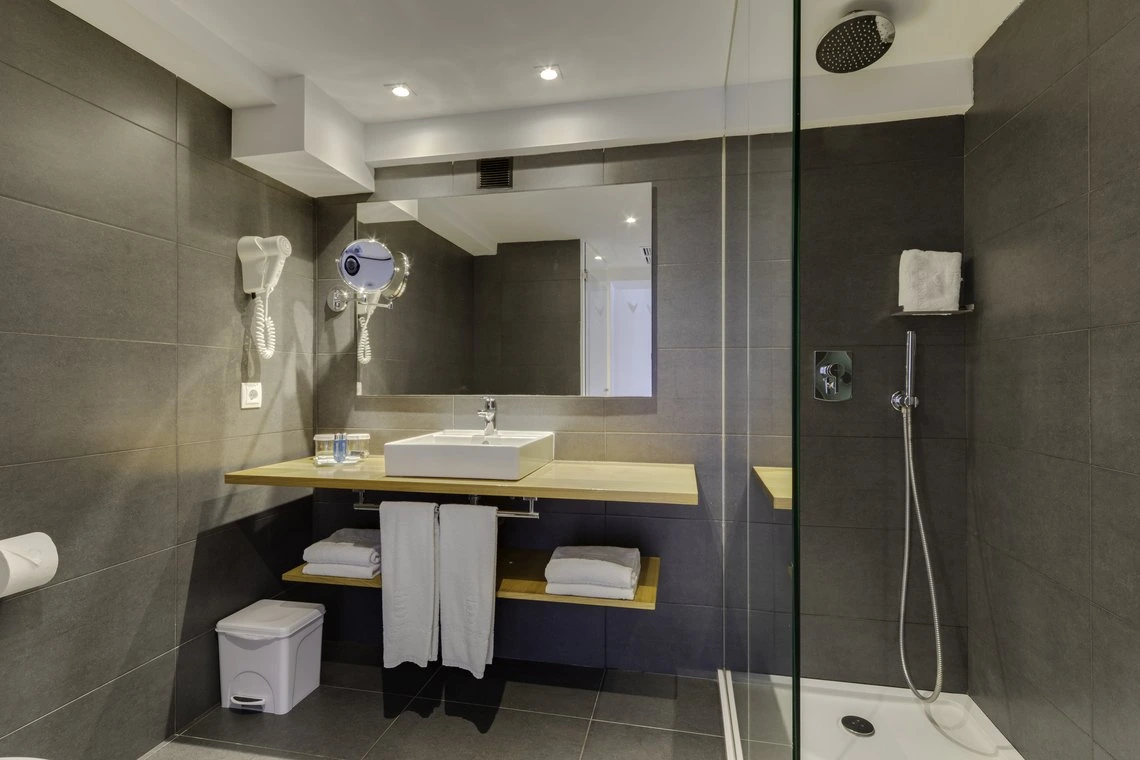 Baño moderno con ducha, lavabo y secador de pelo - tu Playa Esperanza Resort ideal.
