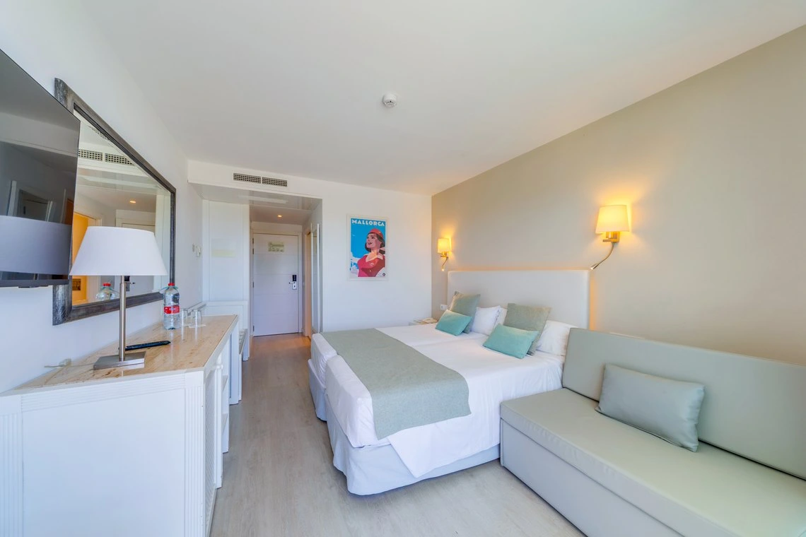 Habitación doble con sofá cama, TV y balcón con vistas. Playa Esperanza Resort