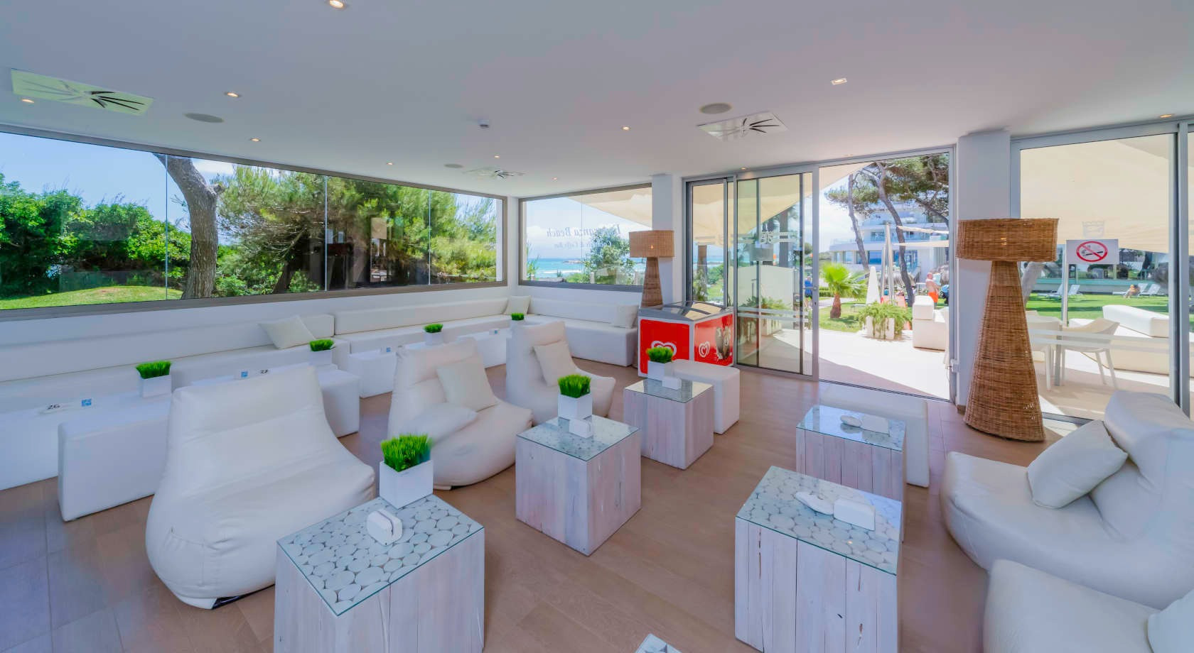 Playa Esperanza Resort: salón moderno con sofás blancos y vistas al mar.