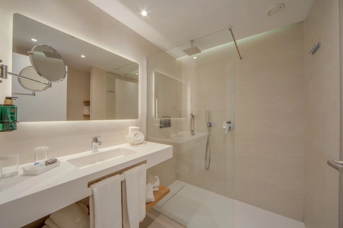 Lujoso baño con ducha de cristal y lavabo moderno, ideal para tu Playa Esperanza Resort.