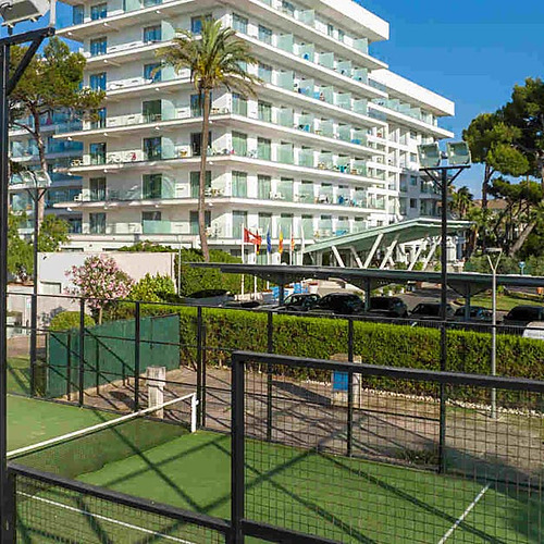 Pistas de pádel y hotel con piscina Playa Esperanza Resort, palmeras y edificios modernos.