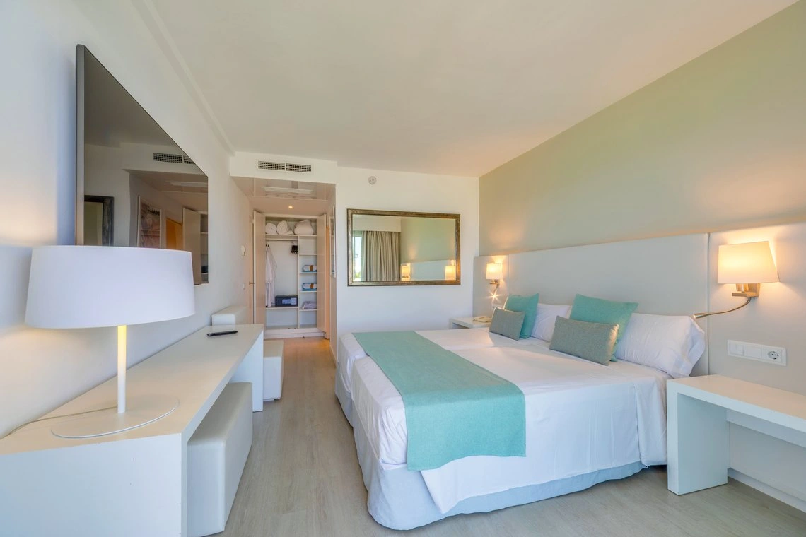 Habitación doble de lujo con TV, espejo y armario. Ideal para Playa Esperanza Resort.
