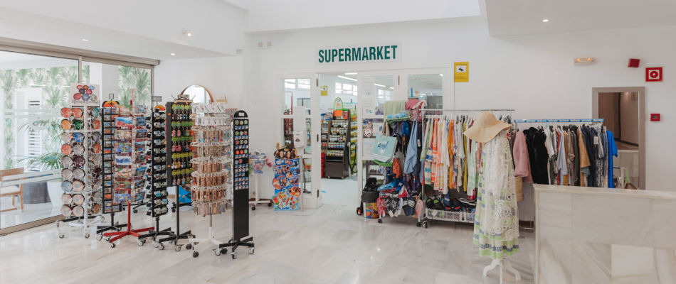 Tienda de souvenirs yropa en hotel, con gafas de sol, postales y ropa de playa. Playa Esperanza Resort