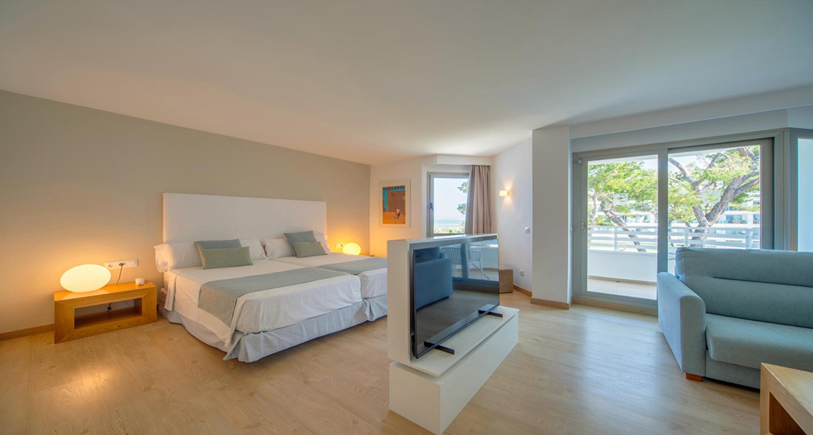 Suite moderna con dos camas, balcón y vista al mar. Playa Esperanza Resort.