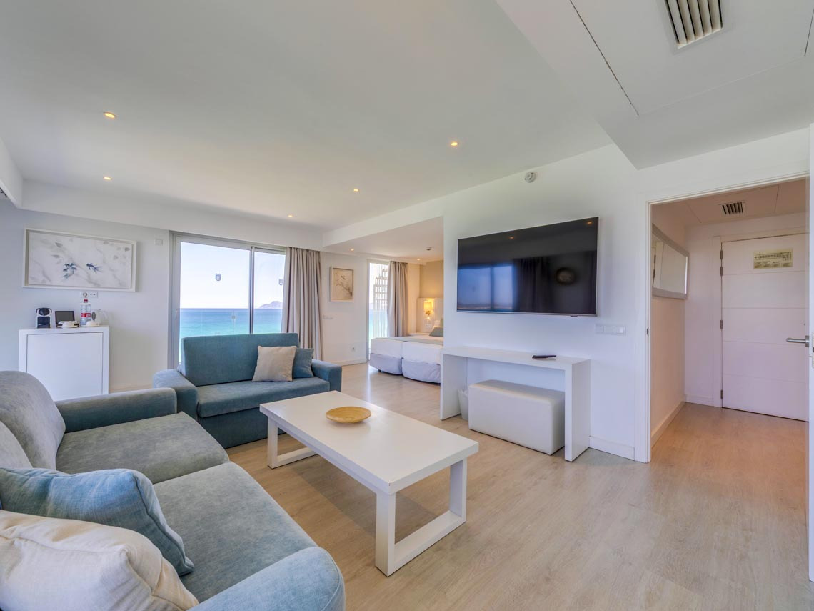 Amplia suite con vista al mar, sala de estar moderna y Playa Esperanza Resort.