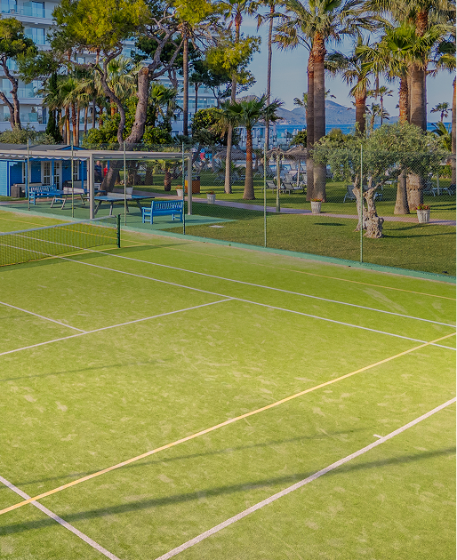 Pista de tenis verde en hotel con palmeras y vista al mar. Playa Esperanza Resort