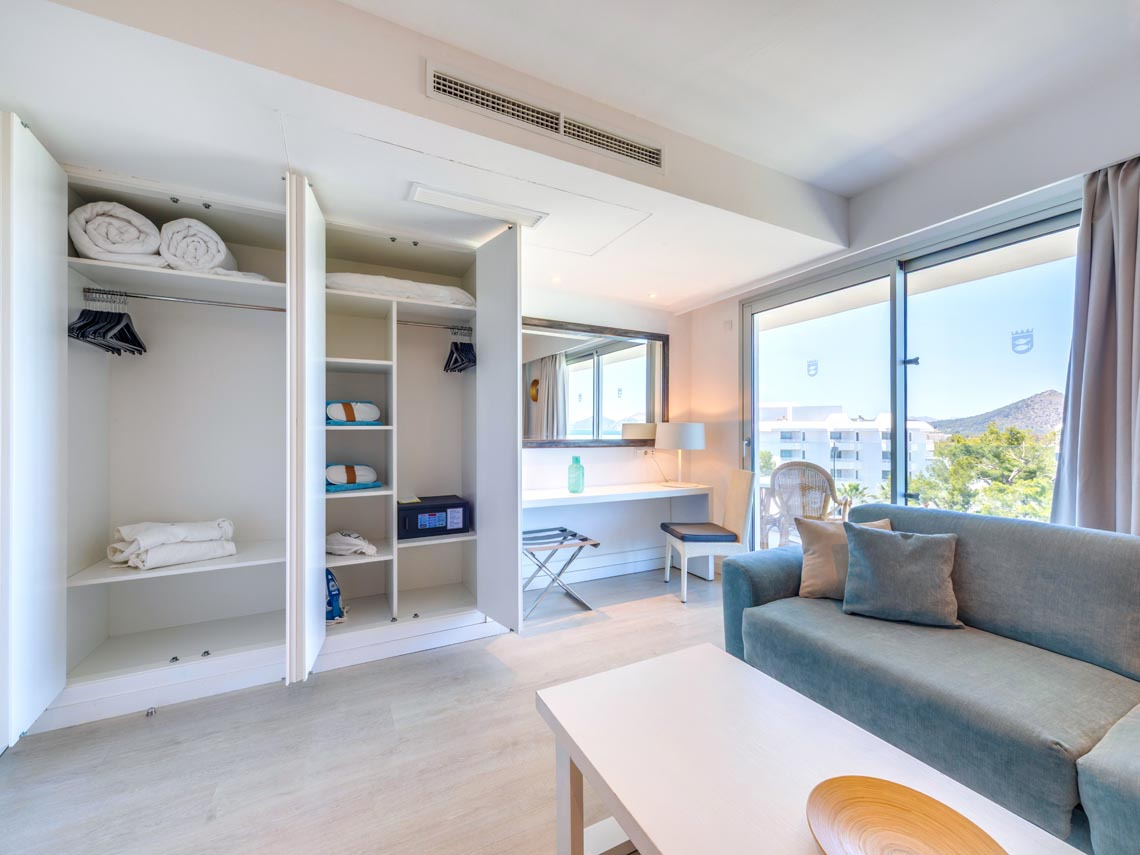 Estudio moderno con armario empotrado, escritorio y sofá, ideal para Playa Esperanza Resort.