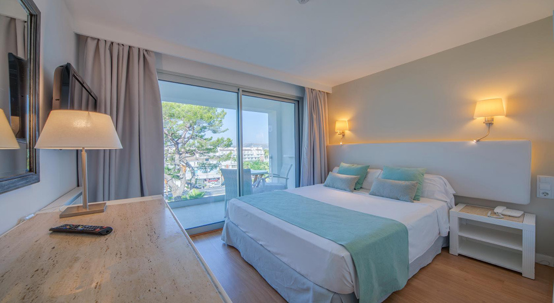 Cómoda habitación de hotel con cama tamaño queen, vista al balcón y comodidades. Playa Esperanza Resort
