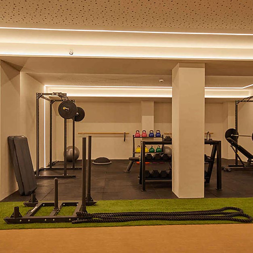 Gimnasio de lujo en hotel con equipo de entrenamiento completo y césped artificial. Playa Esperanza Resort