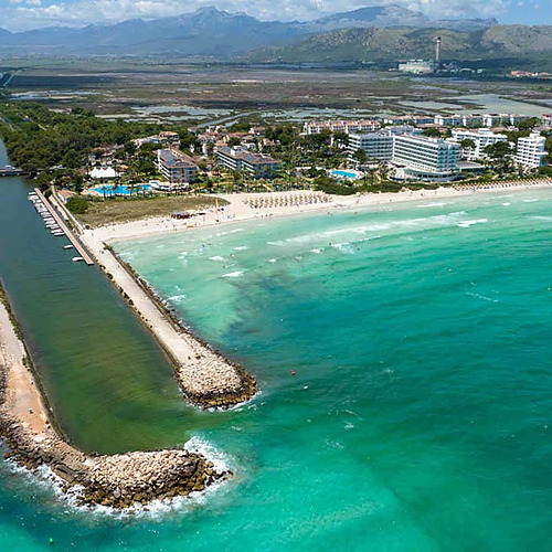Hermosa vista aérea de hotel en la playa Playa Esperanza Resort con piscina y mar turquesa.