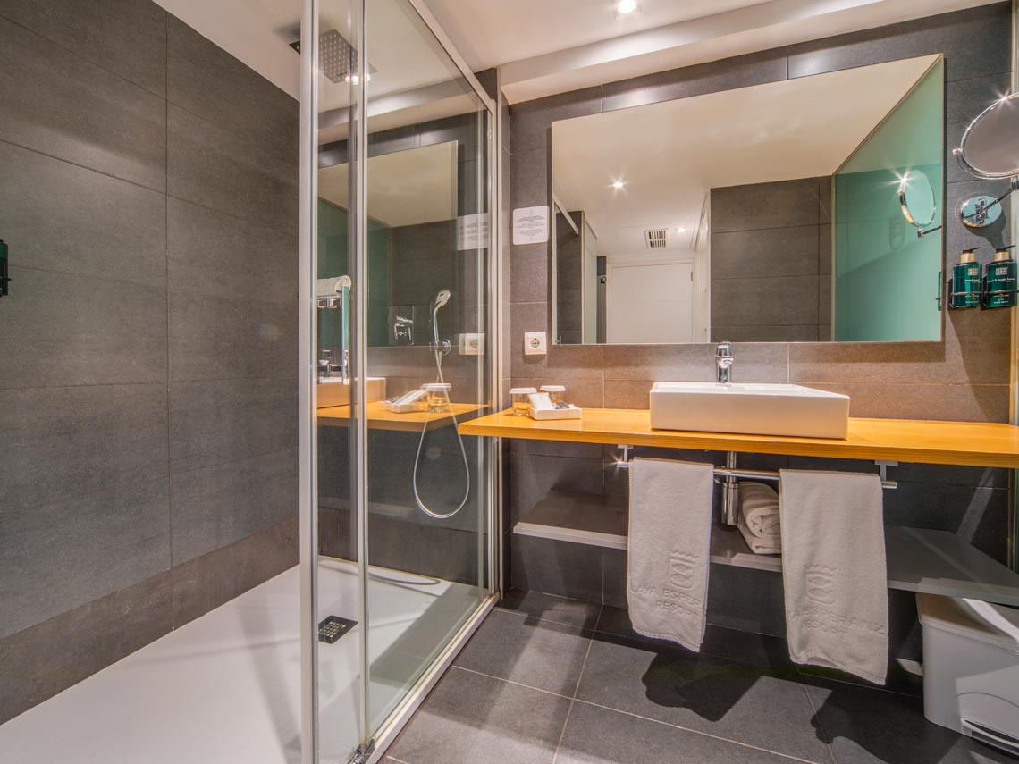 Baño moderno con ducha y lavabo en hotel. Playa Esperanza Resort