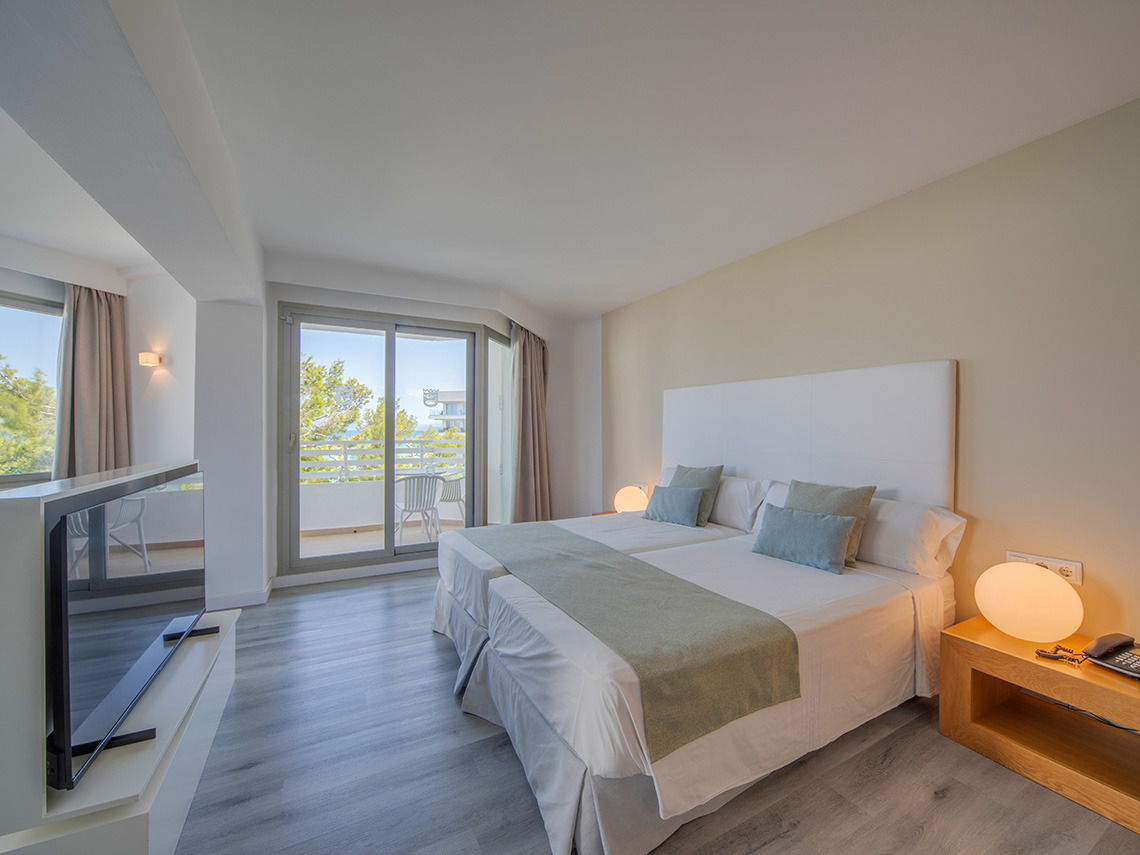Habitación con dos camas, balcón y TV, perfecta para tu Playa Esperanza Resort.