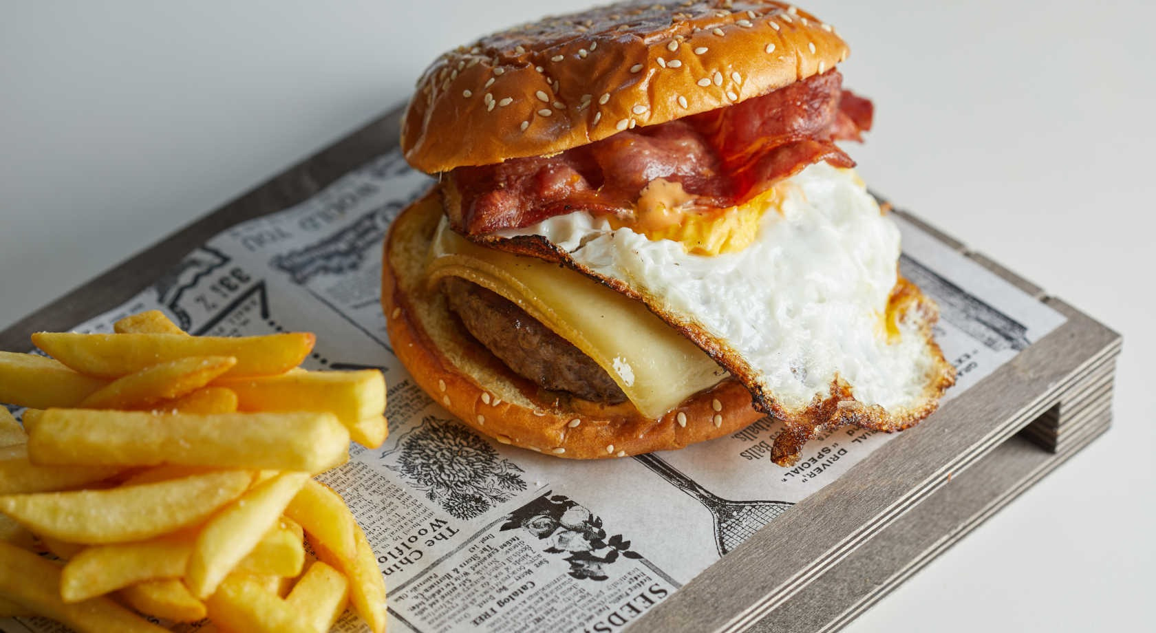 Hamburguesa con huevo frito, tocino, queso y papas fritas, perfecta para Playa Esperanza Resort.