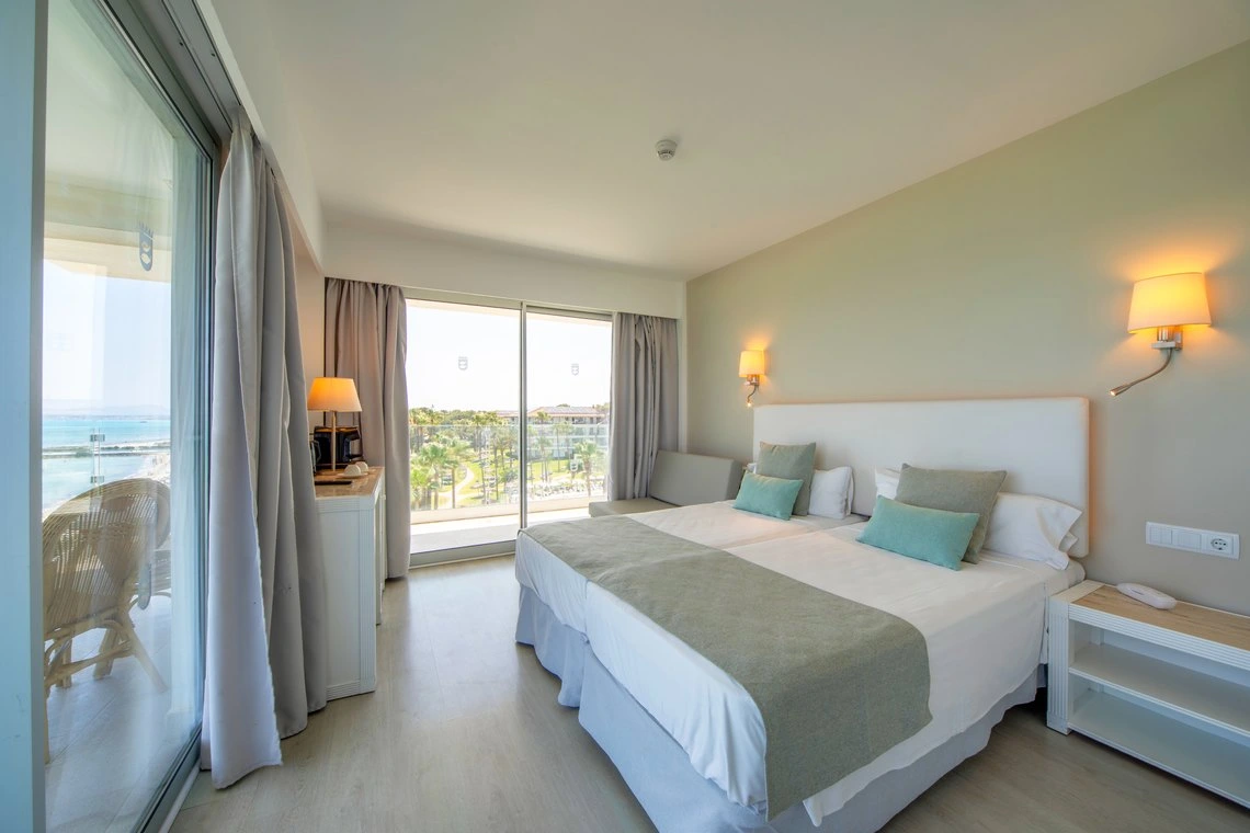 Cama doble de hotel con vista al mar, balcón y decoración moderna. Playa Esperanza Resort