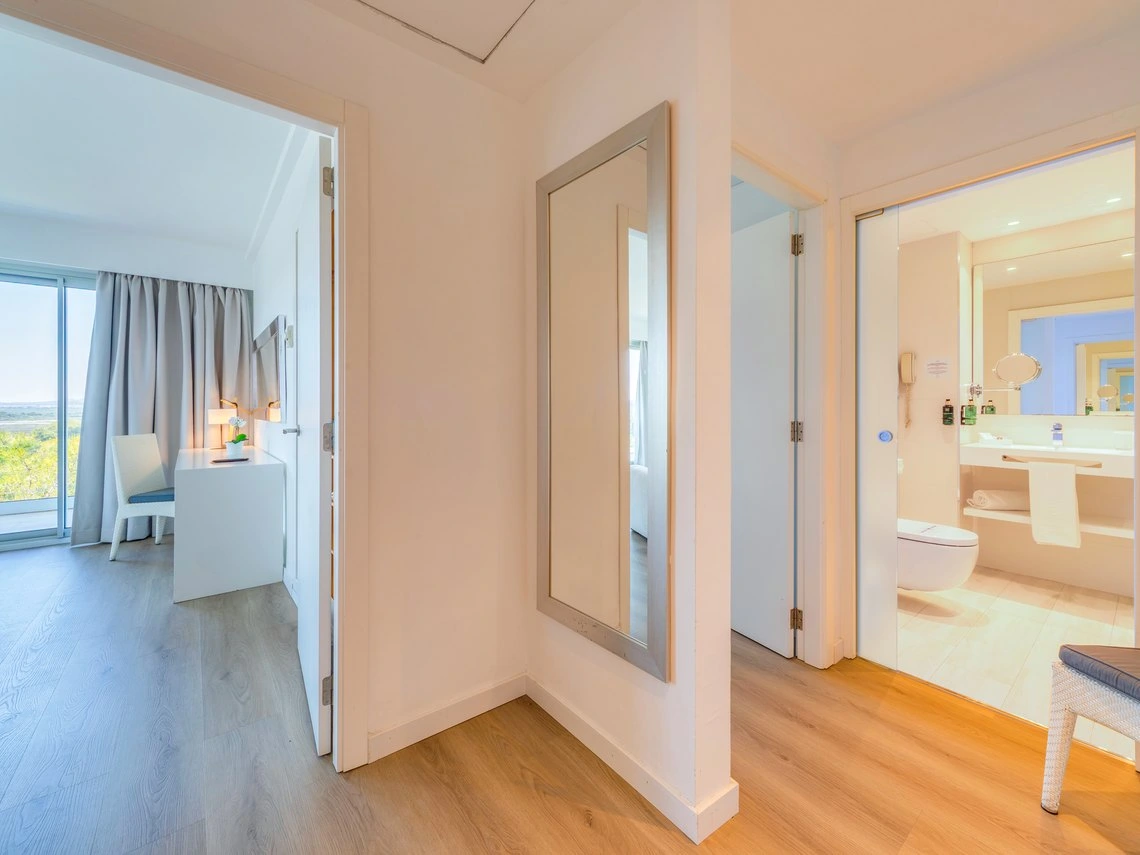 Pasillo de hotel con puerta a habitación y baño. Playa Esperanza Resort