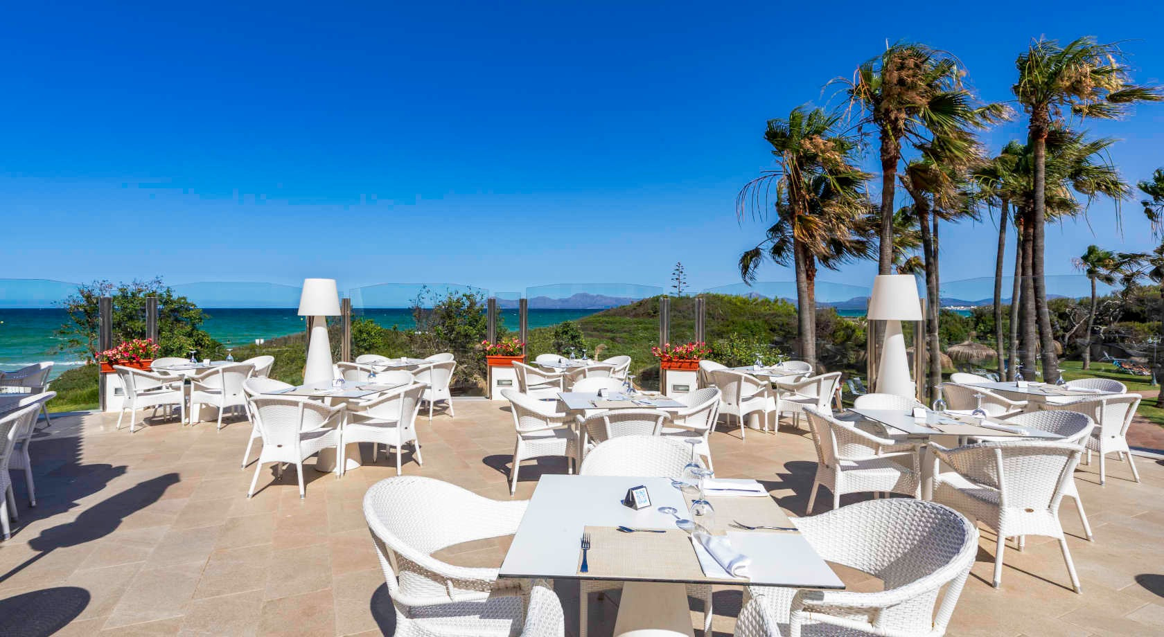 Mesas al aire libre con vista al mar en el hotel Playa Esperanza Resort.