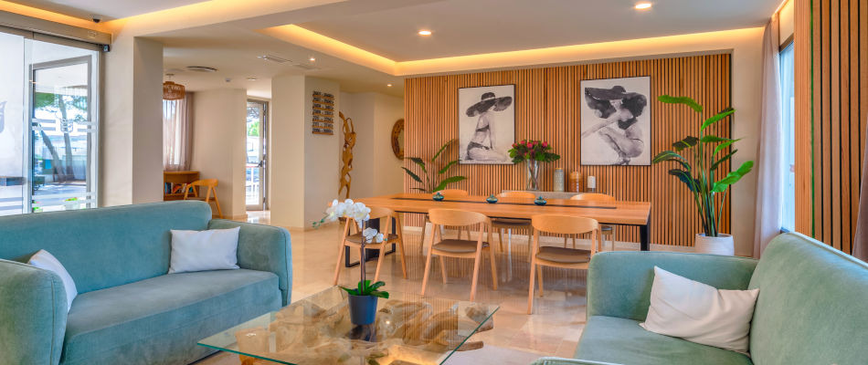 Playa Esperanza Resort acogedor hotel: Sofá verde y mesa de comedor con arte moderno.