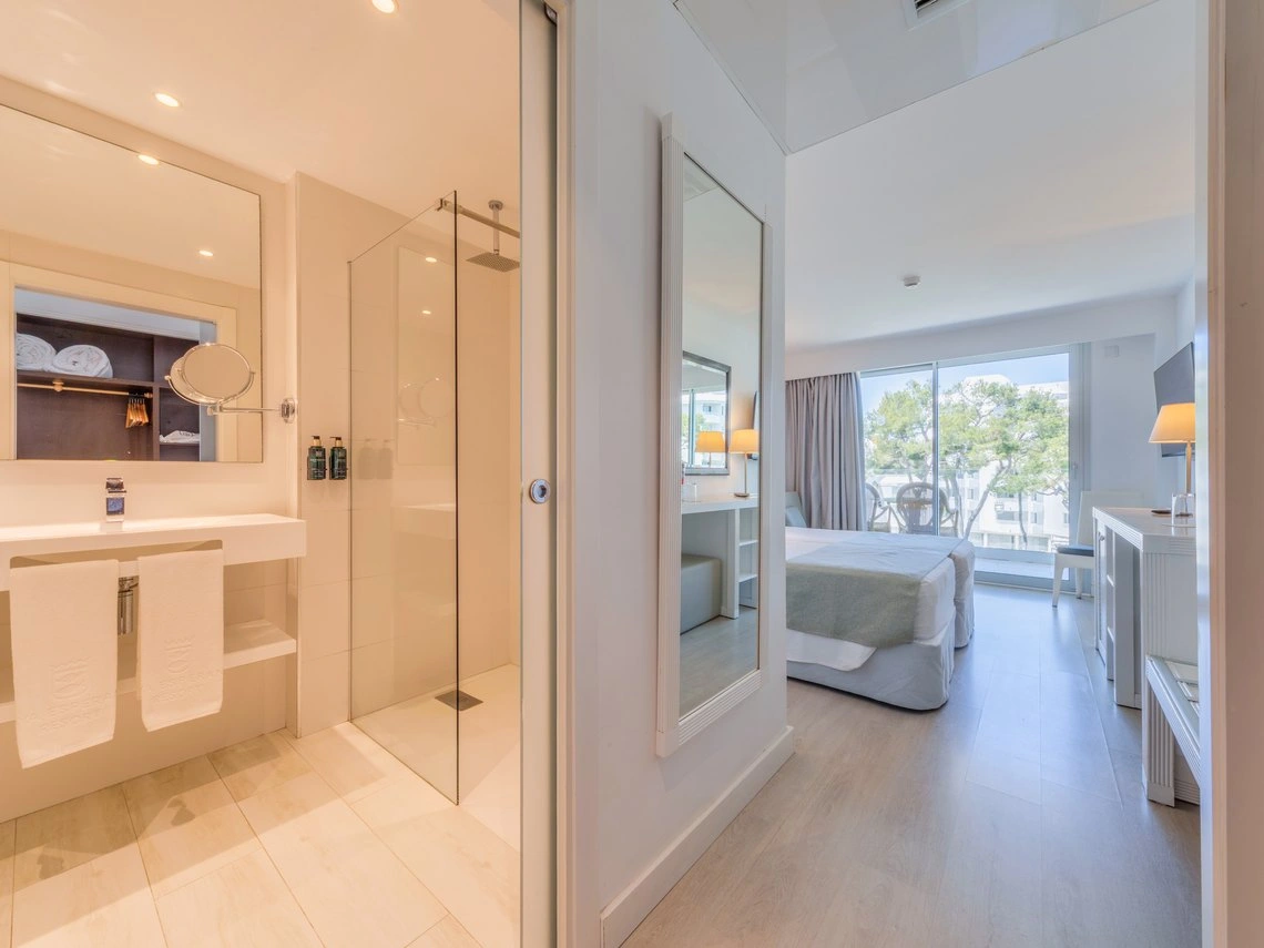 Baño moderno y dormitorio con balcón en Playa Esperanza Resort.