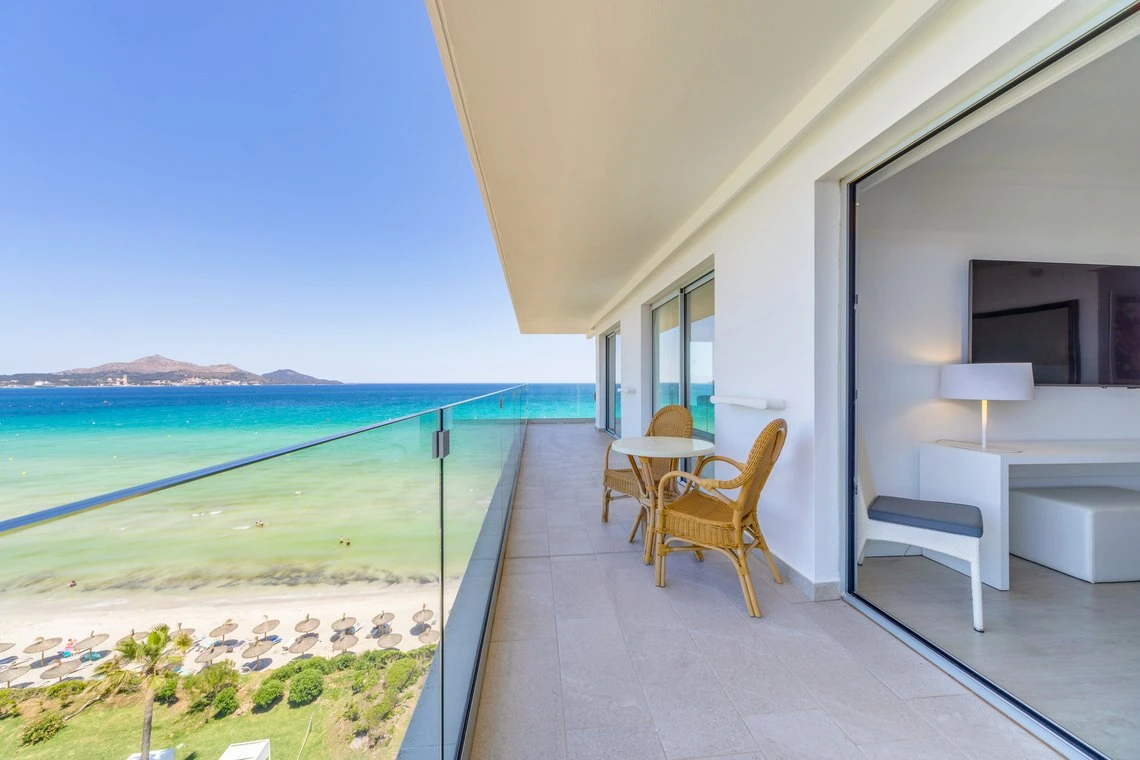 Balcón con vista al mar y sala de estar, ideal para Playa Esperanza Resort.